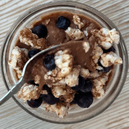 5 Delicous & Easy High-Protein Summer Snacks for Weight Loss 2 chocolate pudding in a bowl with spoon, one of many easy high-protein summer snacks for weight loss.