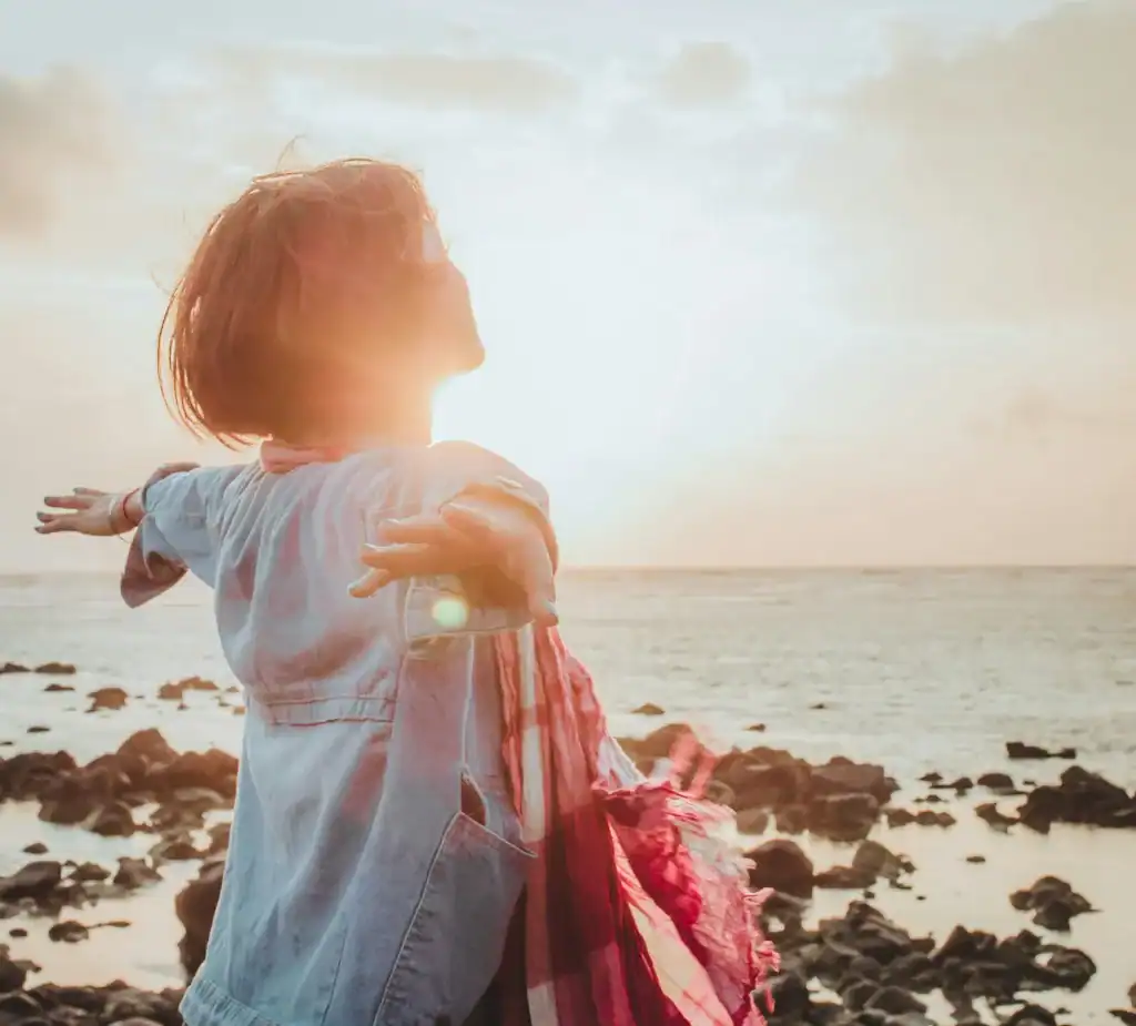 How To Take Care Of Your Mental Health As A New Mom: The Ultimate Guide 13 woman posing by the sunset and ocean.