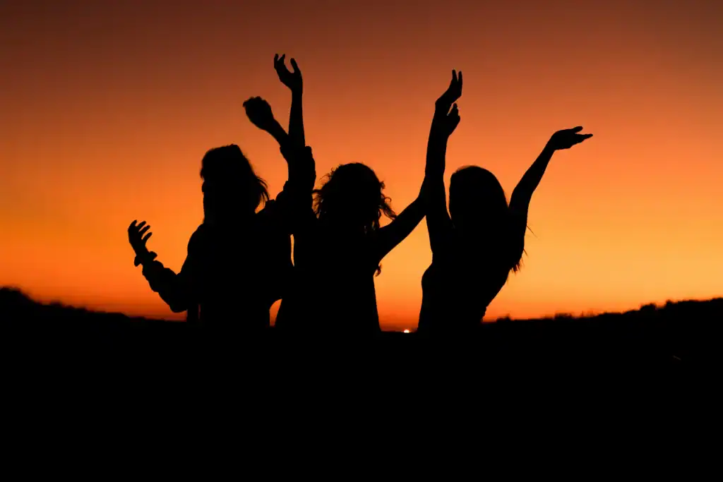 How To Take Care Of Your Mental Health As A New Mom: The Ultimate Guide 12 woman celebrating with a sunset background
